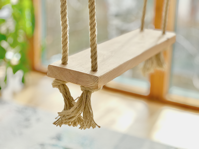 einfache Holzschaukel an Hanfseilen